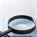 Magnifying glass over a list of health benefits, symbolizing in-depth research.