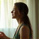 Woman meditating calmly, representing stress management.